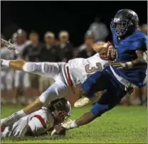  ?? RICK KAUFFMAN — DIGITAL FIRST MEDIA ?? Academy Park’s Dazhon Miller, right, is taken down by West Chester East defenders after gaining some yards Friday night.