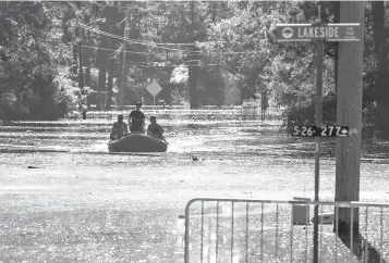  ?? Matt Born/The Star-News via AP
Jason Lee/The Sun News via AP ?? leftU.S. Coast Guardsmen navigate an inflatable boat up Sherwood Drive on Sunday in Conway, S.C., to check on residents.