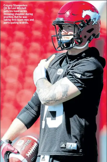  ?? AL CHAREST/POSTMEDIA NETWORK ?? Calgary Stampeders QB Bo Levi Mitchell puts his hand on his throwing shoulder during practice. But he was taking first-team reps and participat­ing in drills.