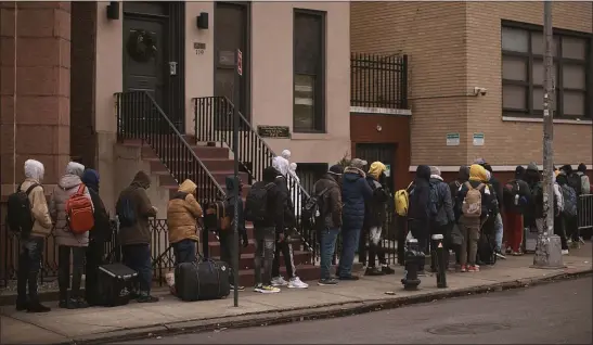  ?? ANDRES KUDACKI, FILE — THE ASSOCIATED PRESS ?? Migrants queue as they look for a shelter outside a migrant assistance center at New York’s St. Brigid Elementary School in December.