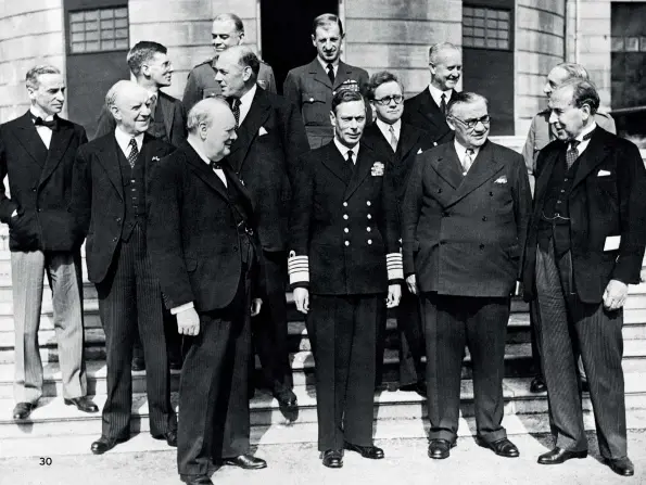  ??  ?? BELOW King George VI with Prime Minister Winston Churchill, Ernest Bevin, Herbert Morrison and other members of cabinet and chiefs of staff, in the grounds of Buckingham Palace. May 8, 1945