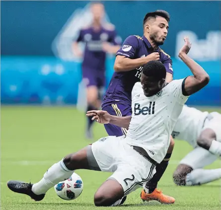  ?? DARRYL DYCK THE CANADIAN PRESS ?? Vancouver Whitecaps’ Doneil Henry, front, collides with Orlando City’s Josue Colman while defending during the first half of an MLS soccer game in Vancouver, on Saturday June 9, 2018.Henry, from Brampton, finds himself in a much better place physically...