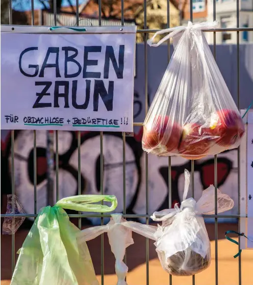  ?? Foto: imago images/Christian Grube ?? Um Bedürftige­n zu helfen, haben Bewohner in Leipzig-Connewitz Beutel mit Nahrungsmi­tteln und Kleidung aufgehängt.