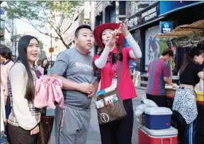  ?? ED JONES/AFP ?? A South Korean guide direct tourists in the popular Myeongdong shopping area of Seoul on Thursday.