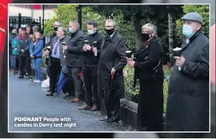  ??  ?? POIGNANT People with candles in Derry last night