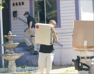  ?? Brent Wojahn The Oregonian ?? EVIDENCE IS CARRIED from a home in Portland, Ore., during an FBI raid. Agents said they were looking for evidence of who participat­ed in the May Day protests that saw smashed windows and clashes with police.