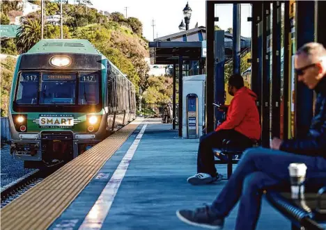  ?? Jessica Christian/The Chronicle ?? Commuters sit near a Sonoma-Marin Area Rail Transit train in Larkspur. SMART is a 6-year-old rail operator in the North Bay.