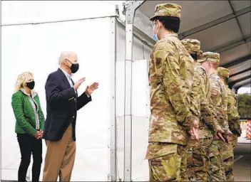  ?? PATRICK SEMANSKY AP ?? President Joe Biden and first lady Jill Biden meet with troops at a vaccinatio­n site Friday in Houston. The president defended his decision to authorize U.S. airstrikes in Syria, calling them a warning to Iran.