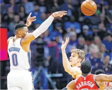 ?? [PHOTO BY NATE BILLINGS, THE OKLAHOMAN] ?? Oklahoma City’s Russell Westbrook passes over Chicago’s Lauri Markkanen and Shaquille Harrison during Monday’s game at Chesapeake Energy Arena.