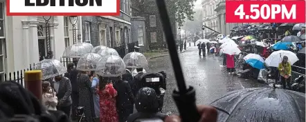  ?? ?? 4.50PM
Downpour St: Crowds huddle in the rain, minutes before Liz Truss strides into No10 in a burst of sunshine