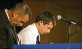  ?? ROBERT FRANKLIN/SOUTH BEND TRIBUNE VIA AP ?? Democratic presidenti­al candidate and South Bend Mayor Pete Buttigieg, right, and South Bend Police Chief Scott Ruszkowski, left, bow their heads in prayer June 23 during a town hall community meeting at Washington High School in South Bend, Ind.