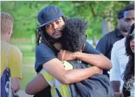  ?? RICK WOOD / MILWAUKEE JOURNAL SENTINEL ?? Frank Nitty hugs Markasa Tucker at Sherman Park Wednesday, where friends and relatives of Sylville Smith gathered.