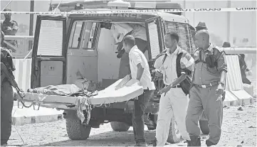  ??  ?? United Nations Mogadishu office staff and Somali soldiers carry the body of a colleague on a stretcher, who was killed in a suicide car bomb attack, following twin car bombings outside the UN’s office in Mogadishu. — AFP photo