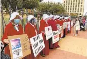  ?? JOHN O'CONNOR AP FILE ?? “Handmaids” protest abortion restrictio­ns at a rally in downtown Springfiel­d, Ill.