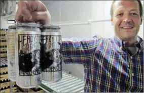  ??  ?? Retail manager Jay Meeks holds a four-pack of Heddy Topper at The Alchemist brewery in Stowe, Vt. The woods of northern New England are luring beer tourists. No discussion of beer in Vermont is complete without The Alchemist, a family run brewery that...