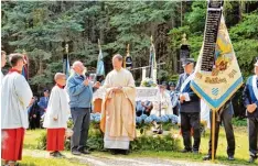  ??  ?? Die restaurier­te Fahne des Krieger und Soldatenve­reins Reinhartsh­ausen wurde von Pfarrer Hubert Ratzinger neu geweiht. Links von ihm der Vereinsvor­sitzende Lauren tius Groll.