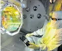  ??  ?? Der Ligo-Detektor in Louisiana
besteht aus zwei langen Röhren, durch die Laserlicht geschickt wird. Rechts im Bild
ist ein Physiker, der das Herzstück des Ligo-Detektors
überprüft: den Spiegel.
