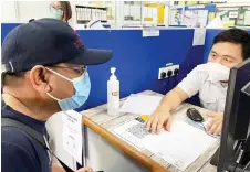  ??  ?? Saibi (left) verifying his personal informatio­n and being interviewe­d by a healthcare worker at the Kota Samarahan Health Clinic.