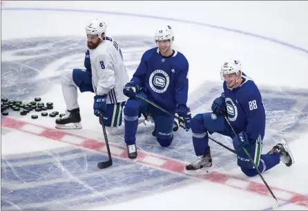  ?? The Associated Press ?? Vancouver Canucks Jordie Benn, from left to right, Elias Pettersson and Nate Schmidt rest during the NHL team’s training camp Monday.