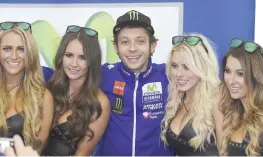  ?? CIAMILLO ?? Valentino Rossi, 36 anni, circondato da quattro umbrella girls, prima delle qualifiche di ieri