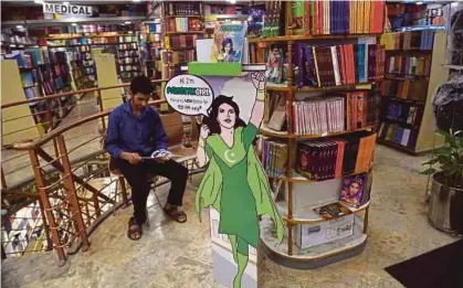  ?? [FOTO AFP] ?? Seorang pelanggan membaca komik bersiri ‘Pakistan Girl’ di sebuah kedai buku di Islamabad, barubaru ini.