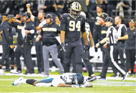  ?? Butch Dill / Associated Press ?? New Orleans defensive end Cameron Jordan offers a hand to Alshon Jeffery, who couldn’t pull in Philadelph­ia’s last pass.