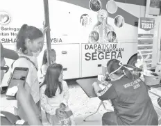  ??  ?? A grandmothe­r and her two grandchild­ren registerin­g for TB screening.