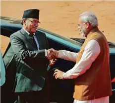  ?? AP ?? Pushpa Kamal Dahal (left) shakes hand with Narendra Modi as he leaves for Rajghat, Mahatma Gandhi memorial from Indian presidenti­al palace, in New Delhi, yesterday.