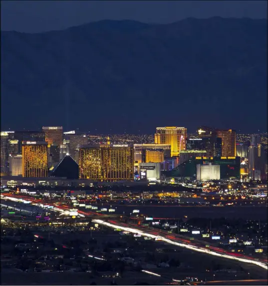  ?? Richard Brian Las Vegas Review-Journal @vegasphoto­graph ?? Traffic moves along Interstate 15 in February as Las Vegas casinos illuminate the city’s skyline at dusk.
