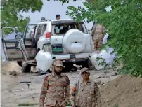  ?? AP ?? Security officials stand guard at the site of the suicide bombing in Mastung district near Quetta on Friday. —