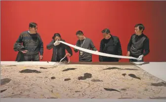  ?? ?? From left: The crew from China Art Museum (Shanghai) prepare the exhibition. Visitors at the exhibition featuring art masters Wu Guanzhong and Lin Fengmian.