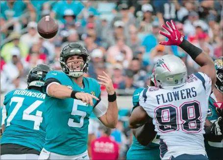  ?? STEPHEN B. MORTON/AP PHOTO ?? Jacksonvil­le quarterbac­k Blake Bortles has a clear view from the pocket as he throws a pass over a rushing Trey Flowers of the Patriots during the Jaguars’ 31-20 victory on Sunday in Jacksonvil­le, Fla.