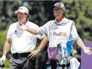  ??  ?? The Associated Press file Caddie Jim Mackay, right, discusses a shot with Phil Mickelson during the first round of the 2015 St. Jude Classic in Memphis, Tenn. Mickelson and his caddie have mutually decided to part ways after 25 years of one of the most...