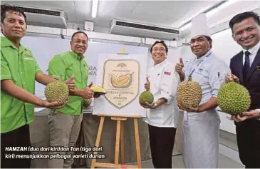  ??  ?? HAMZAH (dua dari kiri)dan Tan (tiga dari kiri) menunjukka­n pelbagai varieti durian.