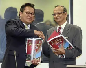  ??  ?? In the spotli ht: Nur Jazlan (left) and Ambrin with copies of the interim audit report in Parliament.