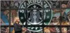  ?? GENE J. PUSKAR — THE ASSOCIATED PRESS ?? Awomanwalk­s past a Starbucks coffee shop in Sewickley, Pa. Starbucks Corp. reported disappoint­ing sales growthat its coffee shops aroundthe world Thursday, and announced that it will sell its Tazo tea brand to Unilever for $384million.