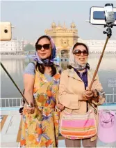  ??  ?? Look at me! Tourists using selfie sticks