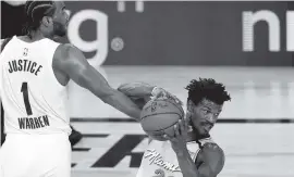  ?? KIM KLEMENT AP ?? Pacers forward T.J. Warren fouls Heat forward Jimmy Butler during Monday’s game in Lake Buena vista. Butler had 12 points in Miami’s victory.