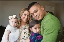  ??  ?? Irwin Obispo (right) and Michelle Obispo, with their daughters Ava, 3, and Olivia, 6 months, in their home.