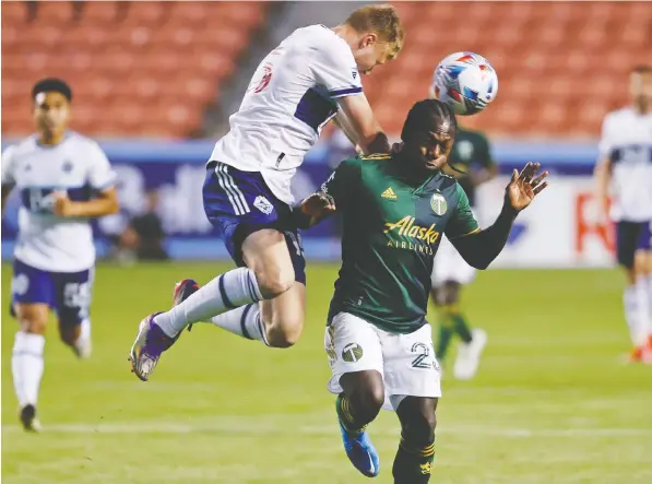  ?? — USA TODAY SPORTS ?? Vancouver Whitecaps FC midfielder Andy Rose, left, and Portland Timbers forward Yimmi Chara battle in the first half at Rio Tinto Stadium.