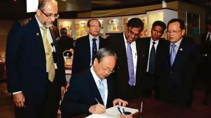  ??  ?? Sontirat Sontijiraw­ong menandatan­gani buku pelawat pada lawatan kerja beliau ke Ibu Pejabat MPOB di Bangi, sambil diperhati Datuk Seri Ahmad Hamzah (kanan).