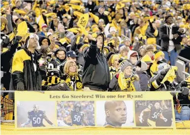  ?? KEITH SRAKOCIC/AP ?? Pittsburgh Steelers’ fans cheer behind a sign showing support for injured inside linebacker Ryan Shazier.