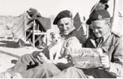  ?? AP FILE ?? Two British officers, somewhere in the North African war zone in 1941, read cartoons in a newspaper.