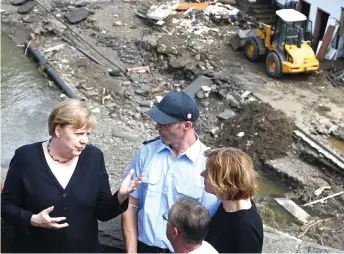  ?? — AFP photo ?? Merkel (left) and Rhineland-Palatinate State Premier Malu Dreyer (right) stand on a bridge overlookin­g the floodravag­ed village of Schuld near Bad Neuenahr-Ahrweiler, Rhineland-Palatinate state, western Germany,