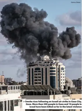  ?? Fatima Shbair ?? > Smoke rises following an Israeli air strike in Gaza City, Gaza. More than 200 people in Gaza and 10 people in Israel have been killed so far in the latest violence