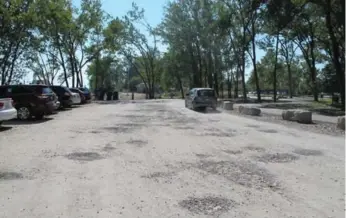  ?? JACK LAKEY/TORONTO STAR ?? A car avoids dozens of potholes that are a perennial problem at Cherry Beach and have proven to be difficult to fix.