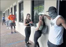  ?? JOE CAVARETTA / SOUTH FLORIDA SUN-SENTINEL VIA AP ?? Brandon Brennan, owner of the Get Fit Academy in Boca Raton, makes sure his clients observe social distancing before opening his gym to a group of eight clients, Tuesday.