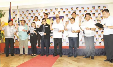  ??  ?? LIBERAL CHANGE — Liberal Party (LP) standard bearer and Department of the Interior and Local Government Secretary Mar Roxas (back row, second from left) is flanked by Ilocos Sur 2nd District Representa­tive Eric D. Singson (left), LP regional chairman,...