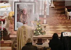  ?? Andreas Schaad/Associated Press ?? Believers and clergy attend a mass for Pope Emeritus Benedict XVI at the Saint Magdalena church on Saturday in Altoetting, Germany.