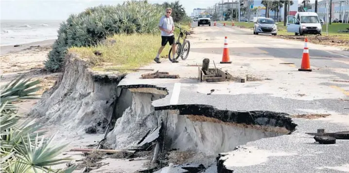  ?? JOE BURBANK/ORLANDO SENTINEL ?? A resident surveys a chunk of A1A that was taken out by high surf from Hurricane Matthew in Ormond-By-The-Sea in 2016. Last year’s storm offers lessons for this year.